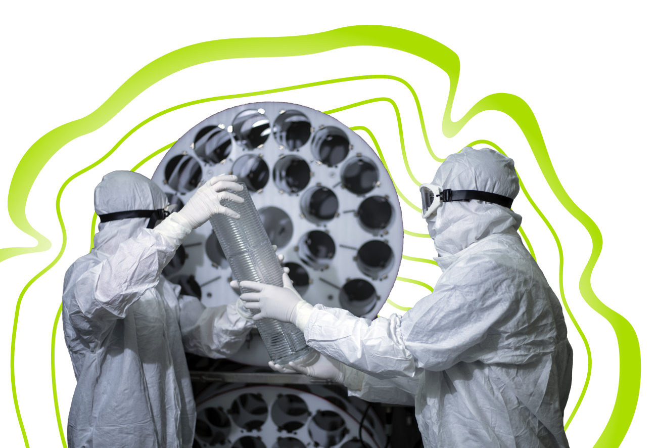 Two technicians in cleanroom suits working together